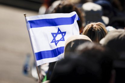 A flag of Israel is seen during a commemoration ceremony at the Bergen-Belsen Memorial in Lohheide, northern Germany on April 27, 2025, on the occasion of the 80th anniversary of the liberation of the Bergen-Belsen concentration camp. The Bergen-Belsen concentration camp was liberated by British forces on April 15, 1945. (Photo by FOCKE STRANGMANN / AFP)