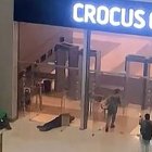 Hombres armados no identificados moviéndose hacia las puertas del Ayuntamiento de Crocus en Krasnogorsk, en las afueras de Moscú-